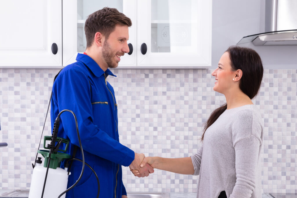 Pest Control Worker Shaking Hands With Woman